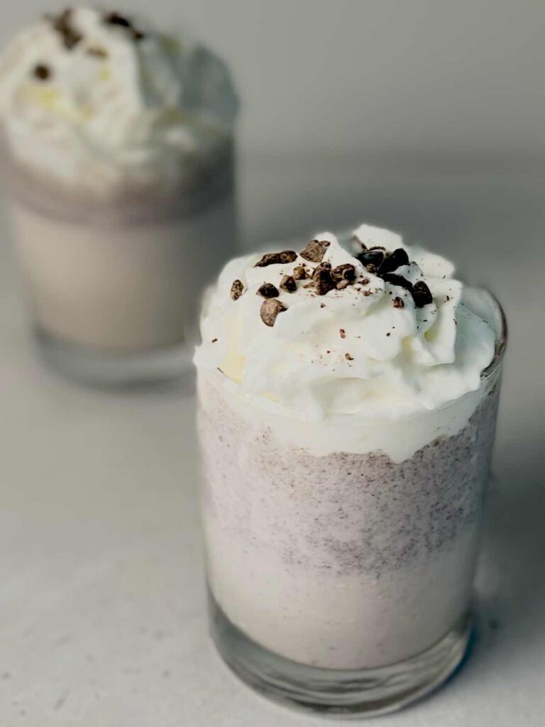 cookies and cream milkshakes topped with whipped cream and grated chocolate