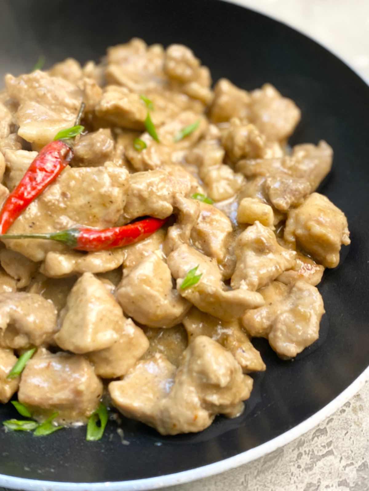 Bicol Express in a wok top with chili peppers 