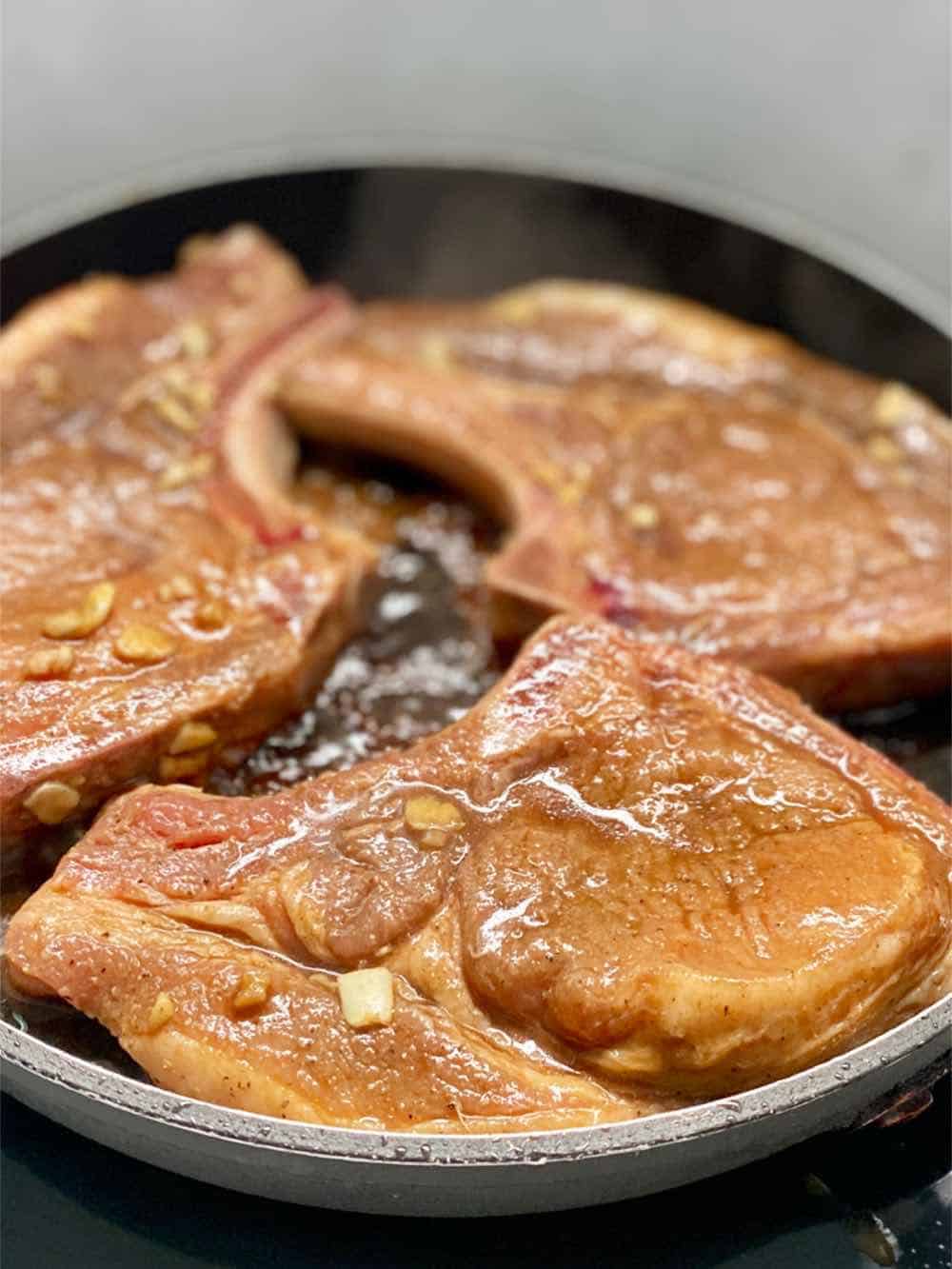 sear three slice of pork chops in a pan