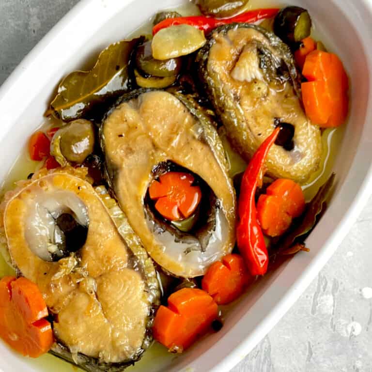 bangus slices with carrots, red peppers in white container