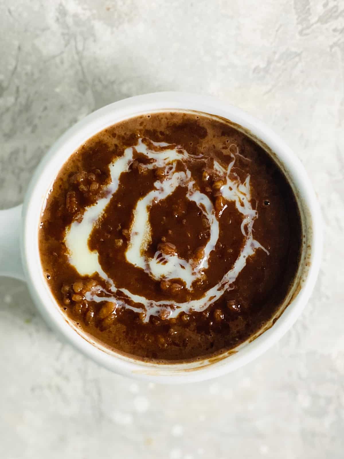 a bowl of champorado recipe with a  drizzle of condensed milk
