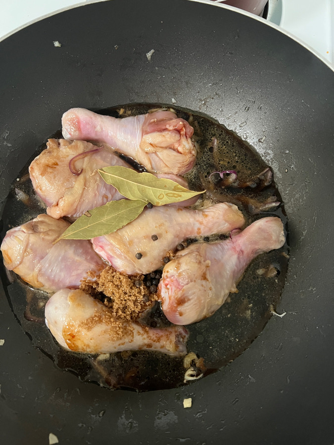 soy sauce, vinegar, sugar, bayleaves added in a pan with chicken