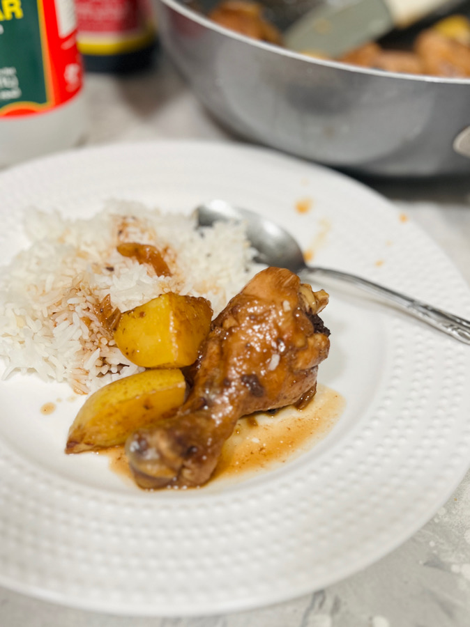 chicken adobo with potatoes in a plate served with rice