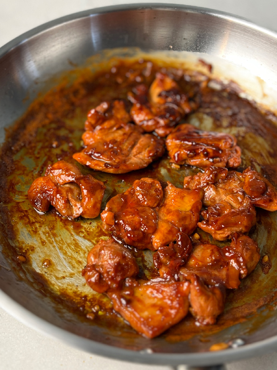 Pan with caramelized chicken tocino sizzling in sauce.