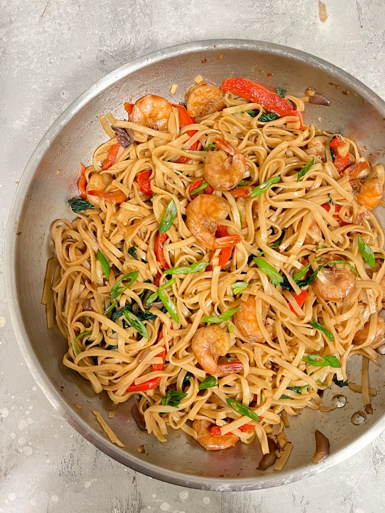 A pan filled with noodles and cooked shrimp.